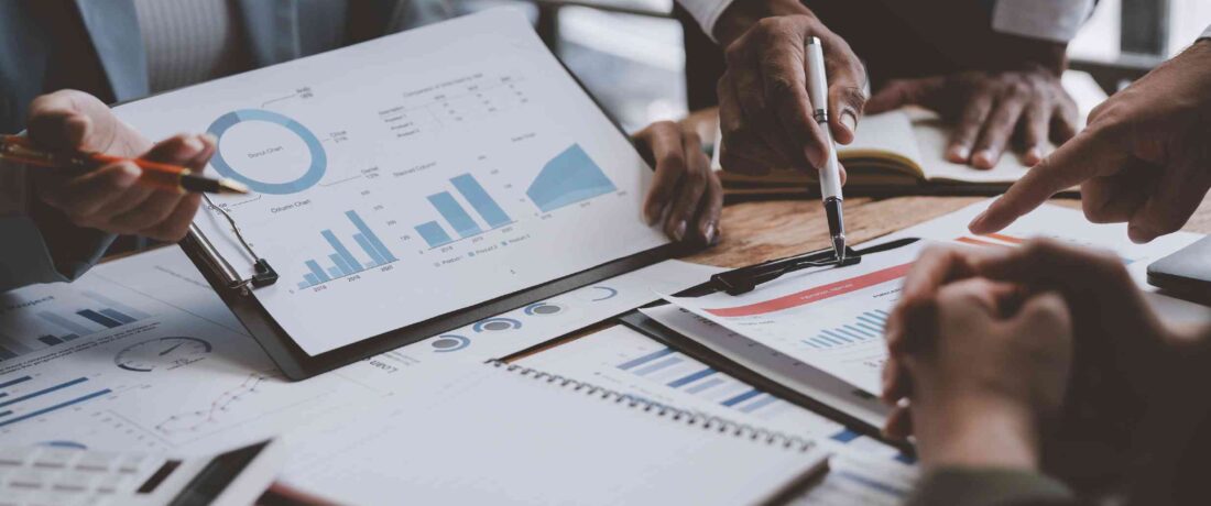 Ejecutivos trabajando en un plan financiero sobre una mesa de una sala de juntas
