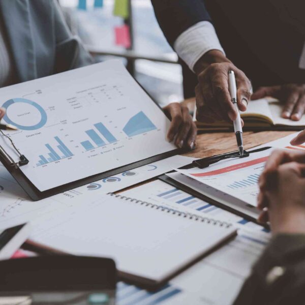 Ejecutivos trabajando en un plan financiero sobre una mesa de una sala de juntas
