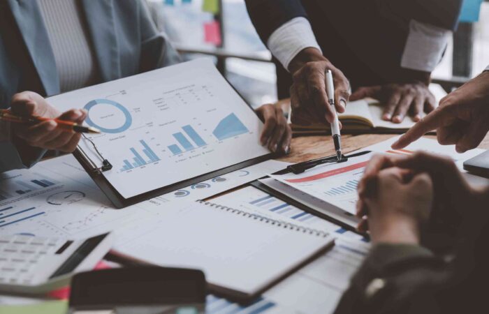 Ejecutivos trabajando en un plan financiero sobre una mesa de una sala de juntas