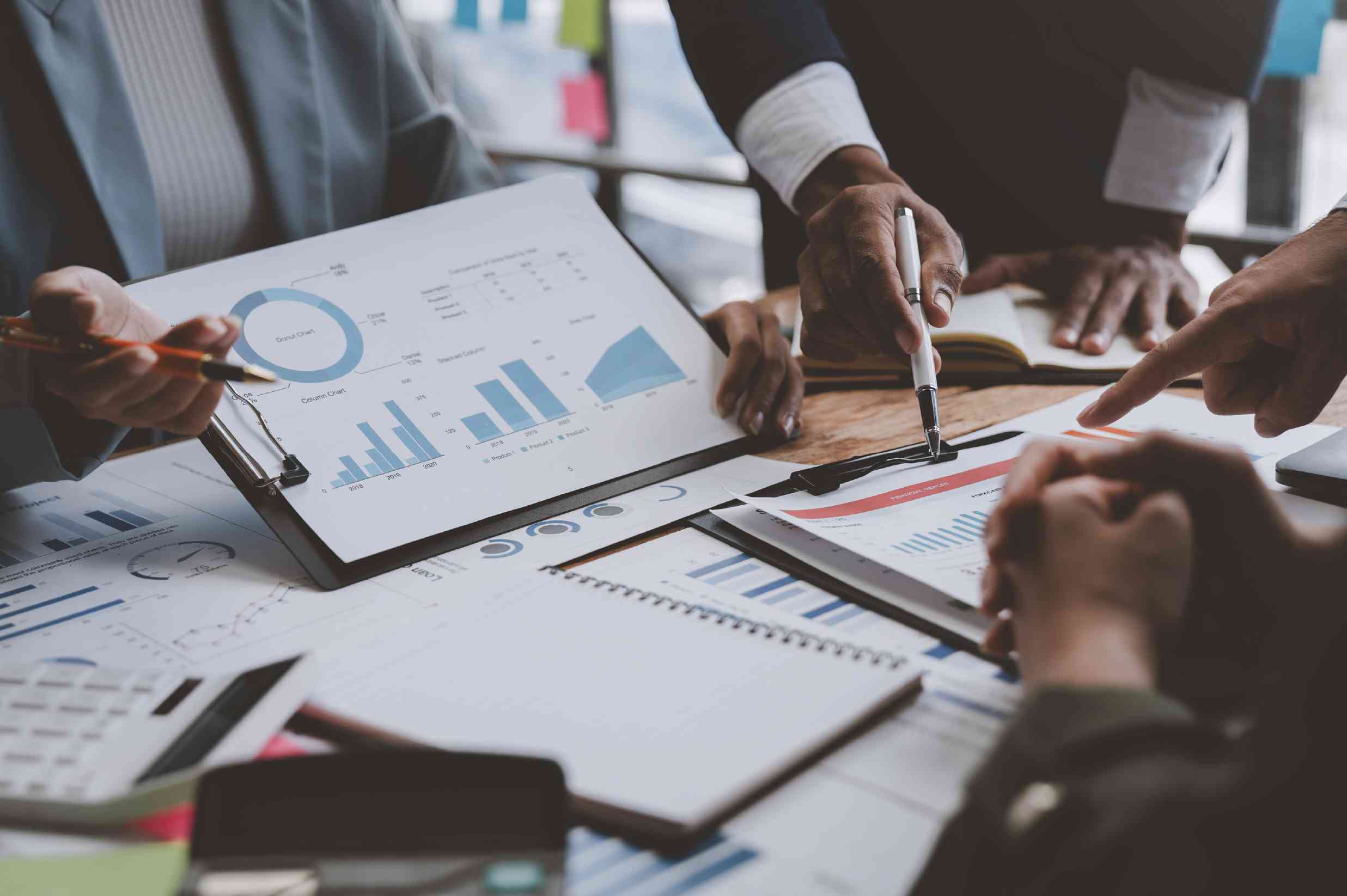 Ejecutivos trabajando en un plan financiero sobre una mesa de una sala de juntas