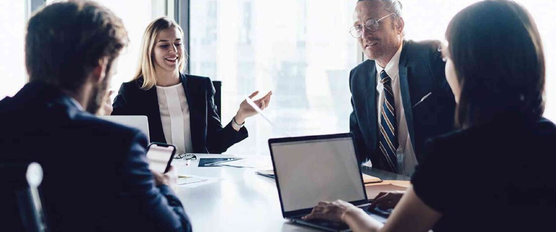 Ejecutivos en una sala de juntas dialogando sobre un plan de consultoría financiera