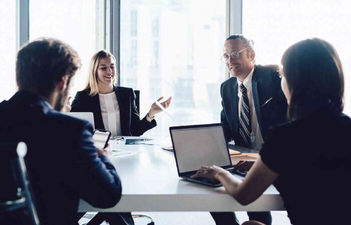 Ejecutivos en una sala de juntas dialogando sobre un plan de consultoría financiera