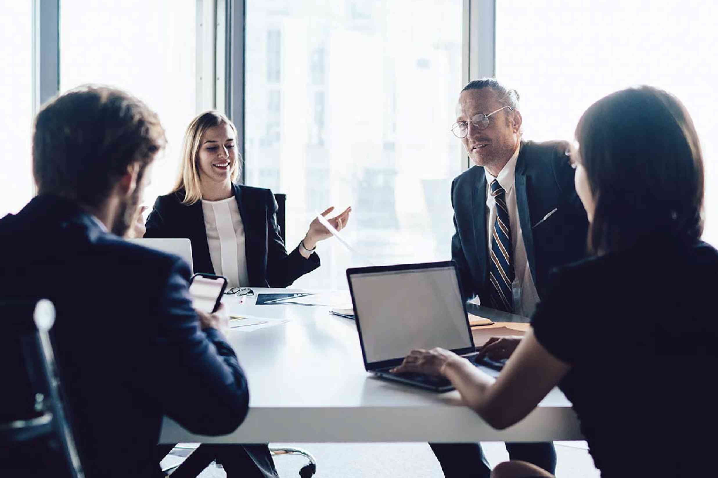 Ejecutivos en una sala de juntas dialogando sobre un plan de consultoría financiera