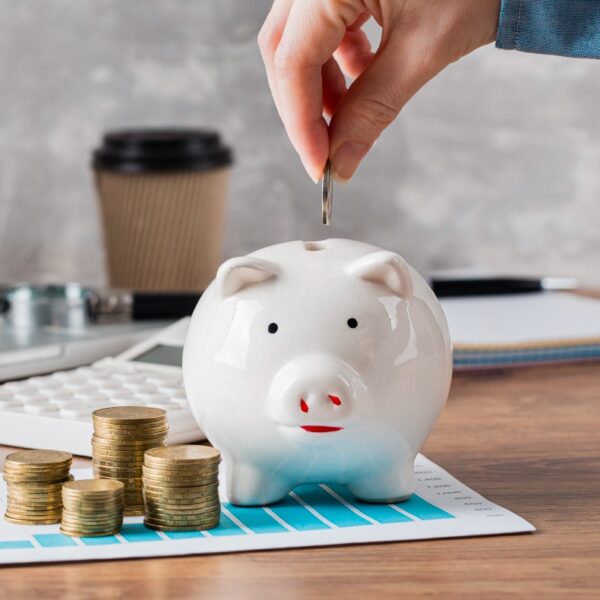 Mano de una persona insertando una moneda en una alcancía
